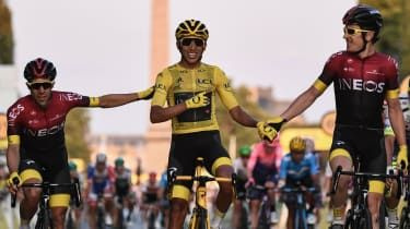 Ridiții echipei Ineos Jonathan Castroviejo (stânga) și Geraint Thomas (dreapta) îl felicită pe Egan Bernal pentru victoria sa în Turul Franței