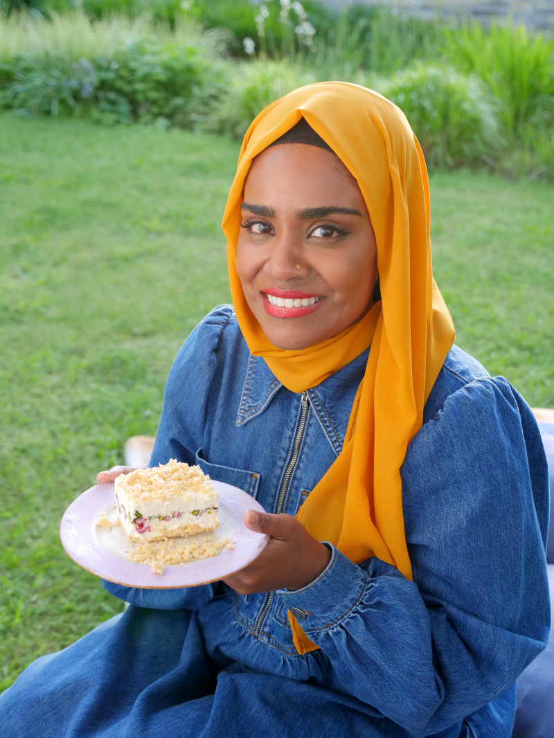   Nadiya houdt haar cheesecake omhoog.