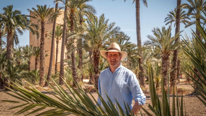   Monty Don con un sombrero de paja se para frente a las palmeras en Monty Don's Spanish Gardens