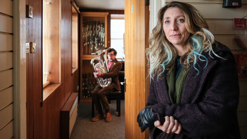   Alan tenant un tuba avec Janet au premier plan dans l'épisode 3 de Boat Story