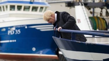 Boris Johnson sa počas návštevy Peterheadu pozerá na vodu z rybárskeho trawleru.