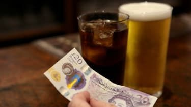 En kund betalar för drycker på en pub med kontanter