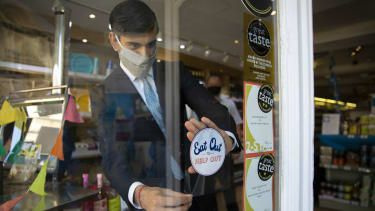 Kanselier Rishi Sunak helpt bij het adverteren van Eat Out To Help Out door stickers op te hangen in deelnemende restaurants