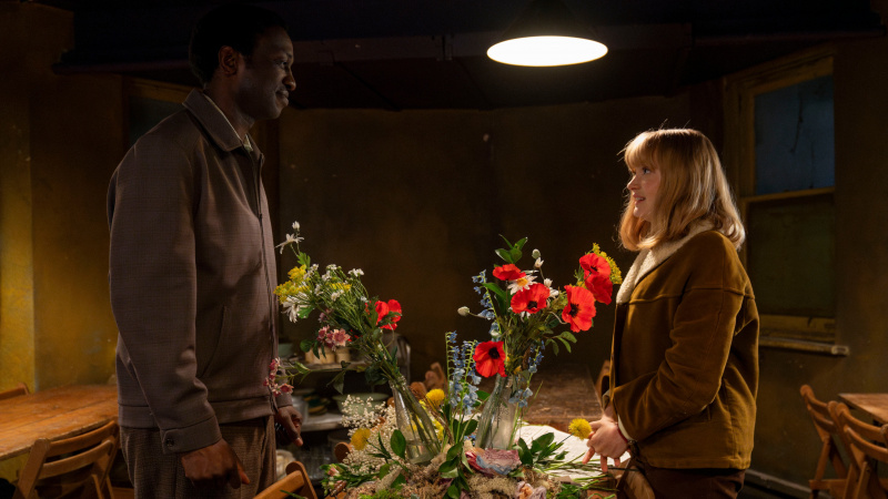   Rosalind a Cyril sa na seba láskyplne pozerajú cez kvetinový aranžmán v Call the Midwife, sezóna 14, 2. diel