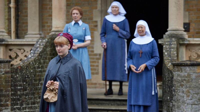   Rosalind, Phyllis, sestra Monica Joan a sestra Julienne stojace na schodoch domu Nonnatus vo svojich uniformách