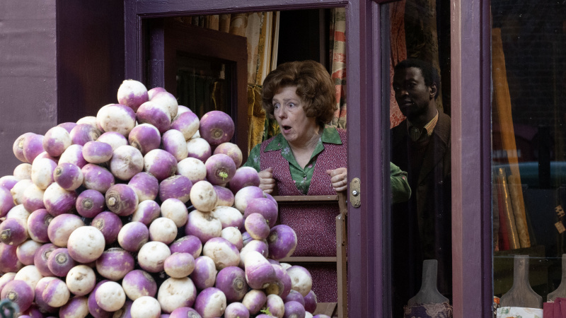   Annabelle Apsion como Violet e Zephryn Taitte como Cyril ficam boquiabertas diante de uma enorme pilha de nabos em Call the Midwife.