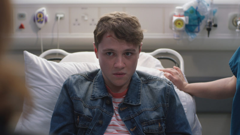   Dominic Sharkey als Ben in een ziekenhuisbed met een snee op zijn hoofd eruit zien alsof hij's in trouble.