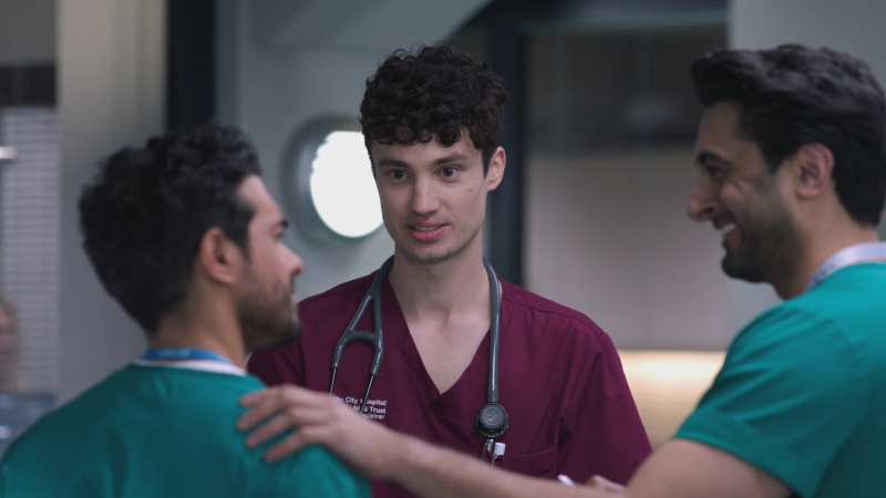   Seth Somers dans le personnage de Sean Redmond portant une blouse marron avec un stéthascope autour du cou.