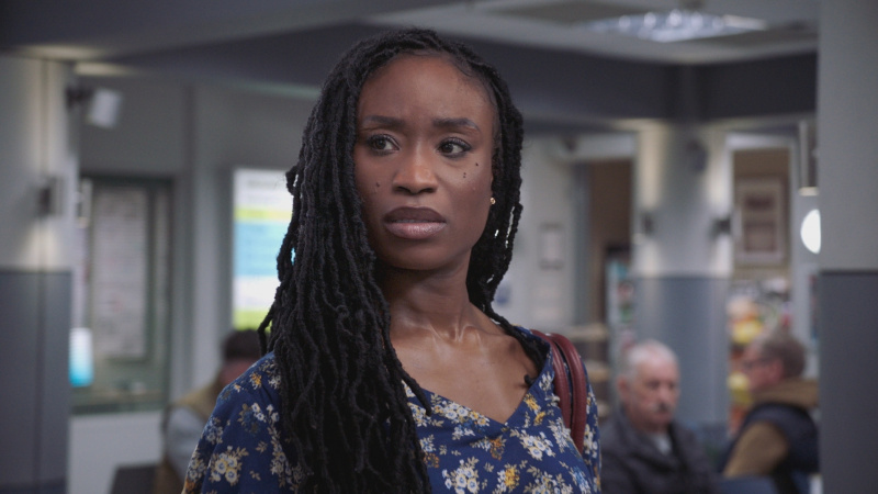   Ngozi สวมเสื้อสีกรมท่าลายดอกไม้ ดูกังวลอย่างมากก่อนเริ่มกะที่ Holby ED