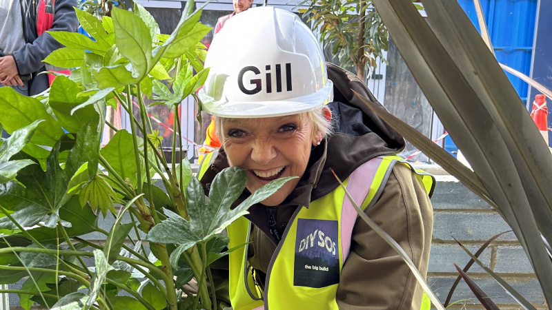   Gillian Wright v prilbe s listovou rastlinou vo filme DIY SOS: EastEnders