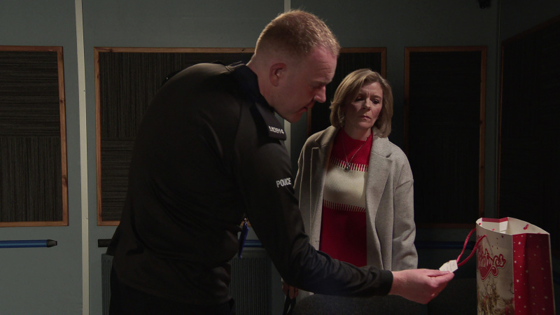  Leanne Battersby şüpheyle onu izlerken Craig Tinker bir Noel hediyesine bakıyor.