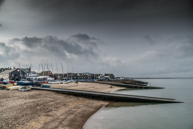   Malebný záber Whitstable Bay s tmavými mrakmi a vlniacim sa morom.