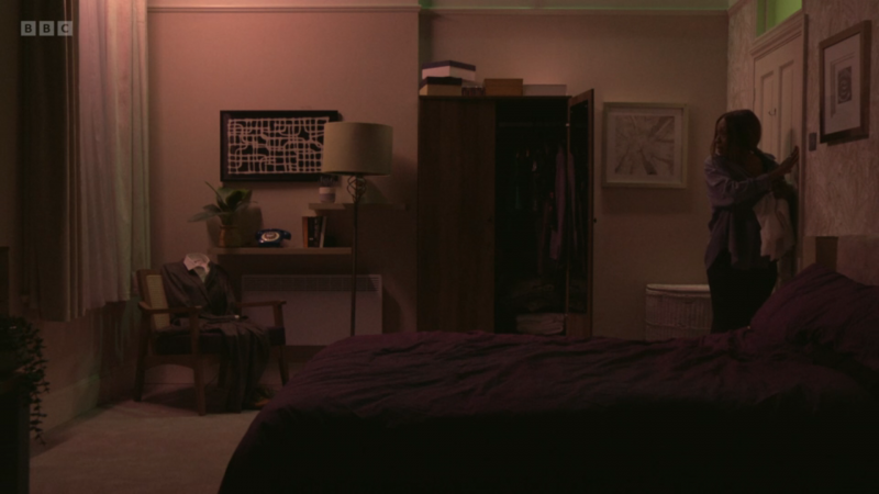   Η Ντενίζ Φοξ βλέπει τον Κιάνου Τέιλορ's suit sitting in a chair in her bedroom.