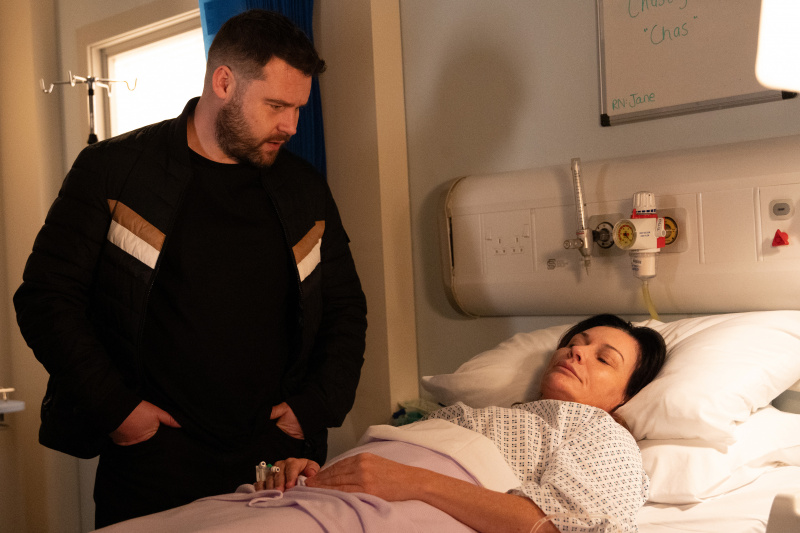   Chas Dingle lamab haiglavoodis, kui Aaron Dingle seisab tema kohal.