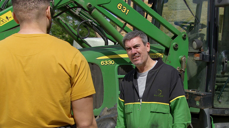  Cain Dingle suočava se s Nateom Robinsonom sa zelenim strojem u pozadini.