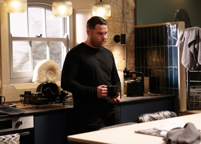  Aaron Dingle näyttää epämukavalta pitäessään mukia kädessään.