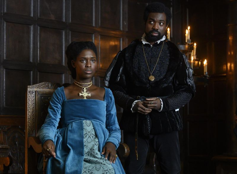 Anne Boleyn (Jodie Turner-Smith) incinta siede a palazzo con il fratello George (Paapa Essiedu) in piedi al suo fianco
