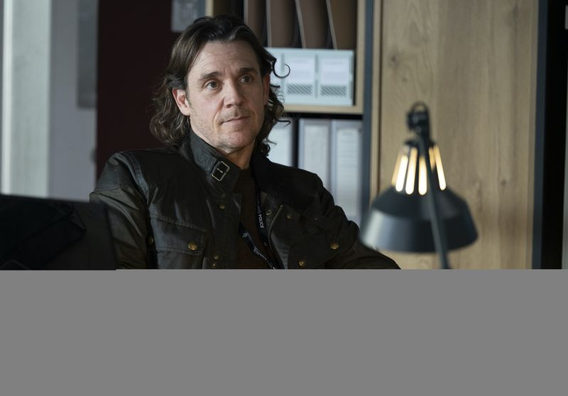 DS Michael McAndrews (Jamie Sives), täysin mustaan ​​pukeutunut, istuu tuolilla merijalkaväen henkirikosyksikössä