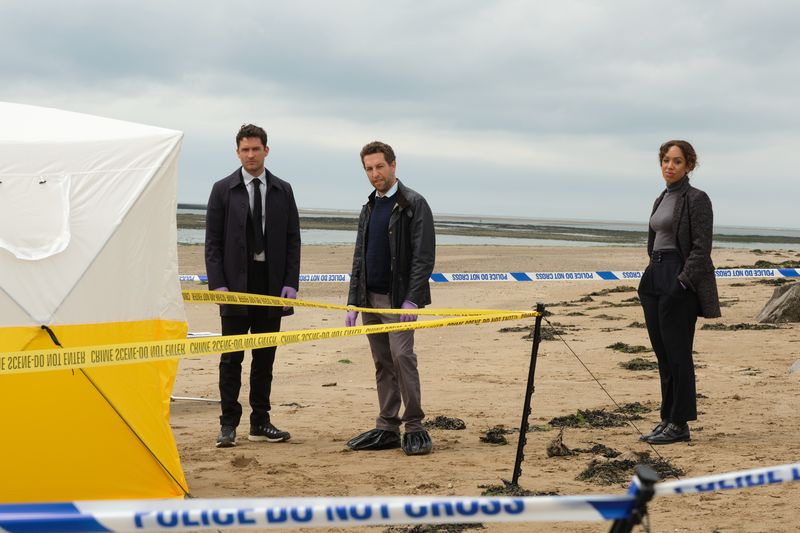 Matthew Venn (Ben Aldridge), Ross Pritchard (Dylan Edwards) e Jen Rafferty (Pearl Mackie) estão em uma praia cercada por fita de cordão policial, atrás de uma tenda de investigação da cena do crime