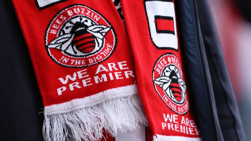 Un fan al lui Brentford poartă o eșarfă care sărbătorește promovarea echipelor în Premier League engleză în timpul amicalelor de pre-sezon dintre Brentford și West Ham United pe Stadionul comunitar Brentford, pe 31 iulie 2021, în Brentford, Anglia.