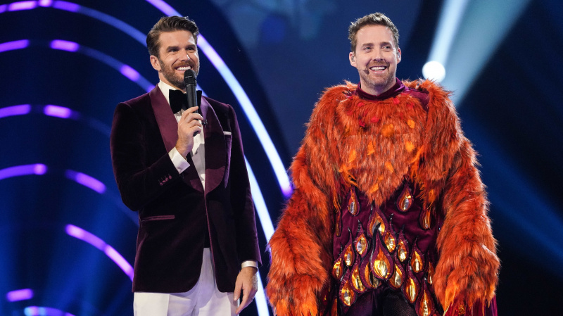   Joel Dommett con Ricky Wilson después de ser desenmascarado como Phoenix en la temporada 4 de The Masked Singer UK