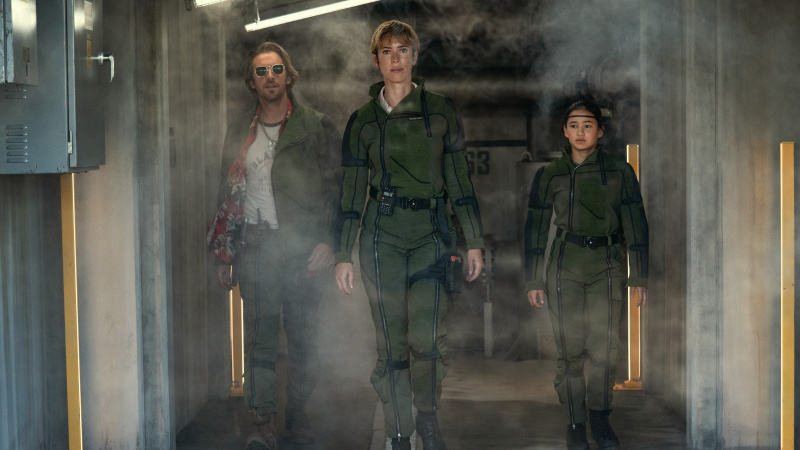   Trapper (Dan Stevens), Ilene Andrews (Rebecca Hall) a Jia (Kaylee Hottle) vychádzajú zo základne Monarch v Godzilla x Kong: The New Empire