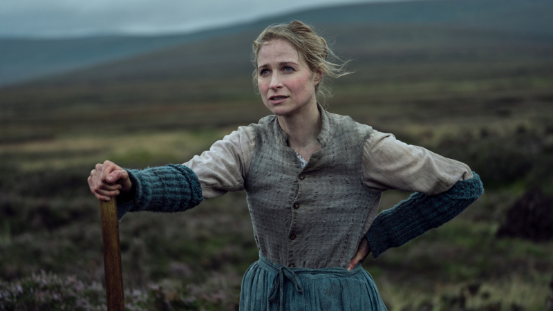   Кити О'Donnell (Niamh Algar) holding a wooden pole outdoors in The Wonder