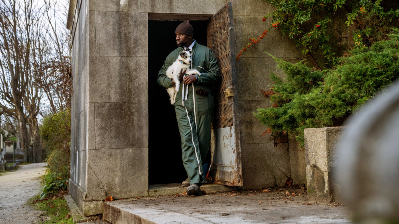  Assane (Omar Sy) verlaat de begraafplaats met zijn hond, J'accuse in Lupin part 3 episode 2