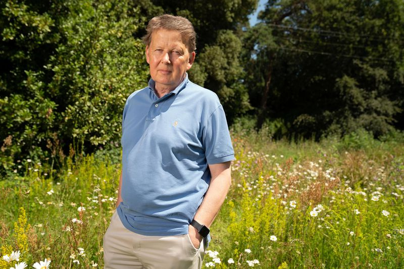 Bill Turnbull poseerinud võttel päikeselisel heinamaal, lõdvestunult, käed taskus