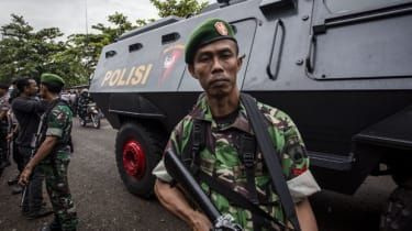 Indonesiske soldater står vagt i nærheden af et indonesisk pansret køretøj med de dømte australske smuglere