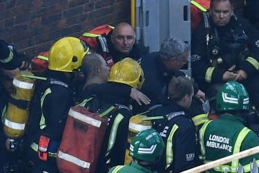 LONDON, ENGLAND - 14. JUNI: En mand bliver reddet af brandfolk, efter at en enorm brand opslugte den 24 etagers boligblok Grenfell Tower i Latimer Road, West London i de tidlige timer af denne m.
