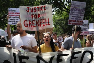 LONDON, ENGLAND - 21. JUNI: Demonstranter holder skilte, der opfordrer til retfærdighed for ofrene for Grenfell-katastrofen og råber slogans, mens de marcherer mod Westminster under et anti-regeringsprotest