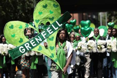 LONDON, ENGLAND - 14. JUNI: Folk holder hyldest, mens de går til Wall of Truth for at markere et-årsdagen for Grenfell Tower-branden den 14. juni 2018 i London, England. I en af Bri