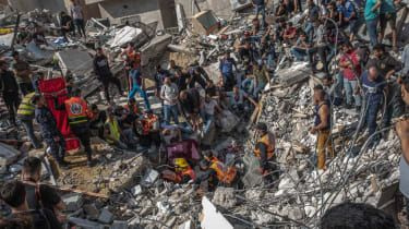 Palestinci iščejo trupla med ruševinami bombardirane zgradbe