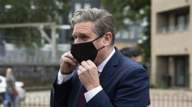 Keir Starmer poartă o mască neagră.