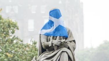 Steagul Saltire al Scoției drapat peste o statuie a romancierului și dramaturgului scoțian Sir Walter Scott din Edinburgh