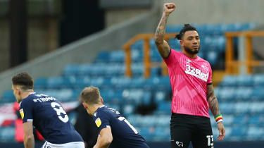Colin Kazim-Richards iz Derby Countyja dvigne desno pest, ko drugi igralci klečejo pred tekmo proti Milwallu