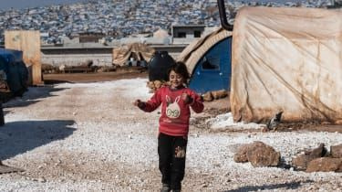 IDLIB, SYRIA - 20. helmikuuta: Siirtymä syyrialainen tyttö juoksee pakolaisleirillä Atmehin kylässä lähellä Syyrian ja Turkin rajaa 20. helmikuuta 2020 Idlibissä, Syyriassa. Turkin presidentti Recep Tayyi
