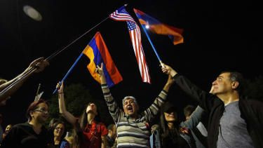 Folk viftar med armeniska och amerikanska flaggor framför USA:s ambassad i Jerevan i april 2021 efter att president Biden formellt utsett slakten av armenierna som ett