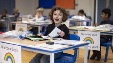  Dzieci siedzą przy społecznie zdystansowanych biurkach w Harris Academy w Londynie