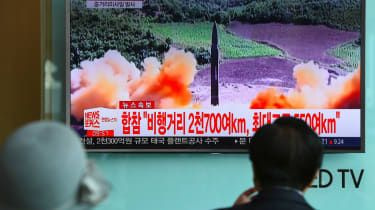 Folk ser nyhedsskærm, der viser nordkoreansk missilaffyring