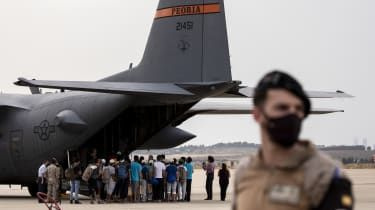 Afghanske flygtninge står i kø for at komme ombord på et amerikansk militærfly