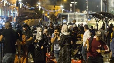 Palestinci bežijo pred izraelskimi varnostnimi silami v bližini mošeje Al-Aksa