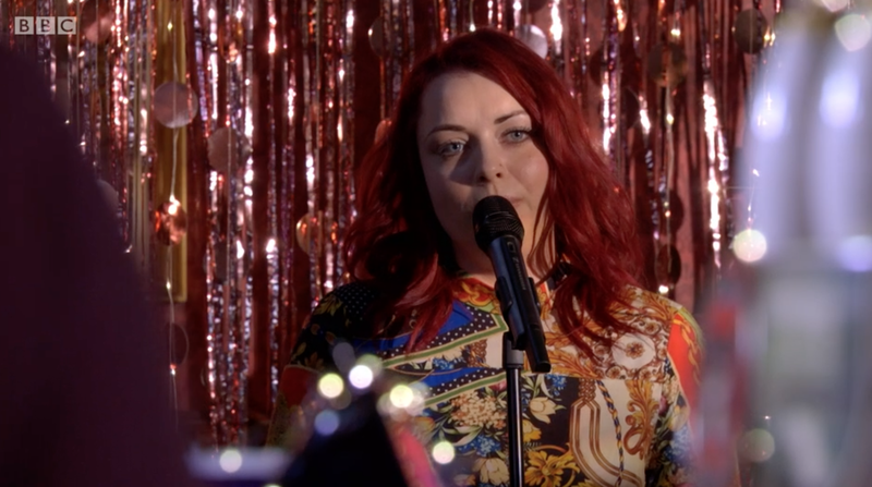 Shona McGarty dainuoja scenoje kaip Whitney Dean filme EastEnders