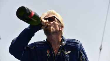Richard Branson pije šampanské po inauguračnom lete do vesmíru na palube lode Virgin Galactic