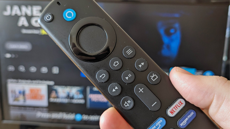   รีโมต Fire TV Stick 4K จัดขึ้นที่หน้าทีวีที่แสดง Fire OS