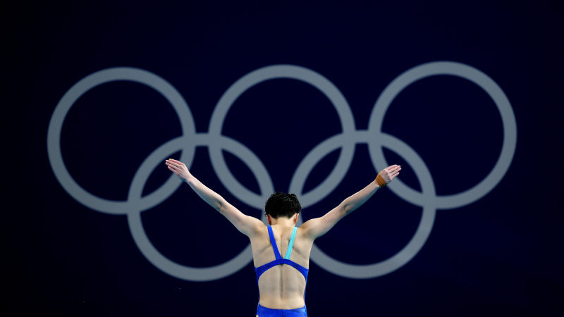 Yiwen Chen pripravuje ponor pred symbolom olympijského kruhu.