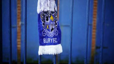 Rute Bury FC visijo na ograji pred stadionom Gigg Lane kluba EFL League One