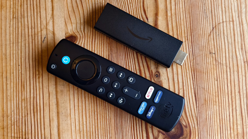   Amazon Fire TV Stick บนโต๊ะไม้ข้างรีโมท