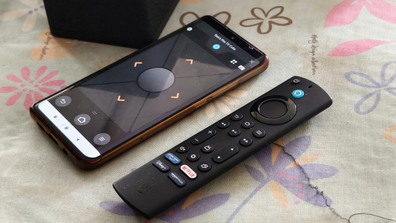   Een smartphone met de Amazon Fire TV-app naast de Alexa-afstandsbediening